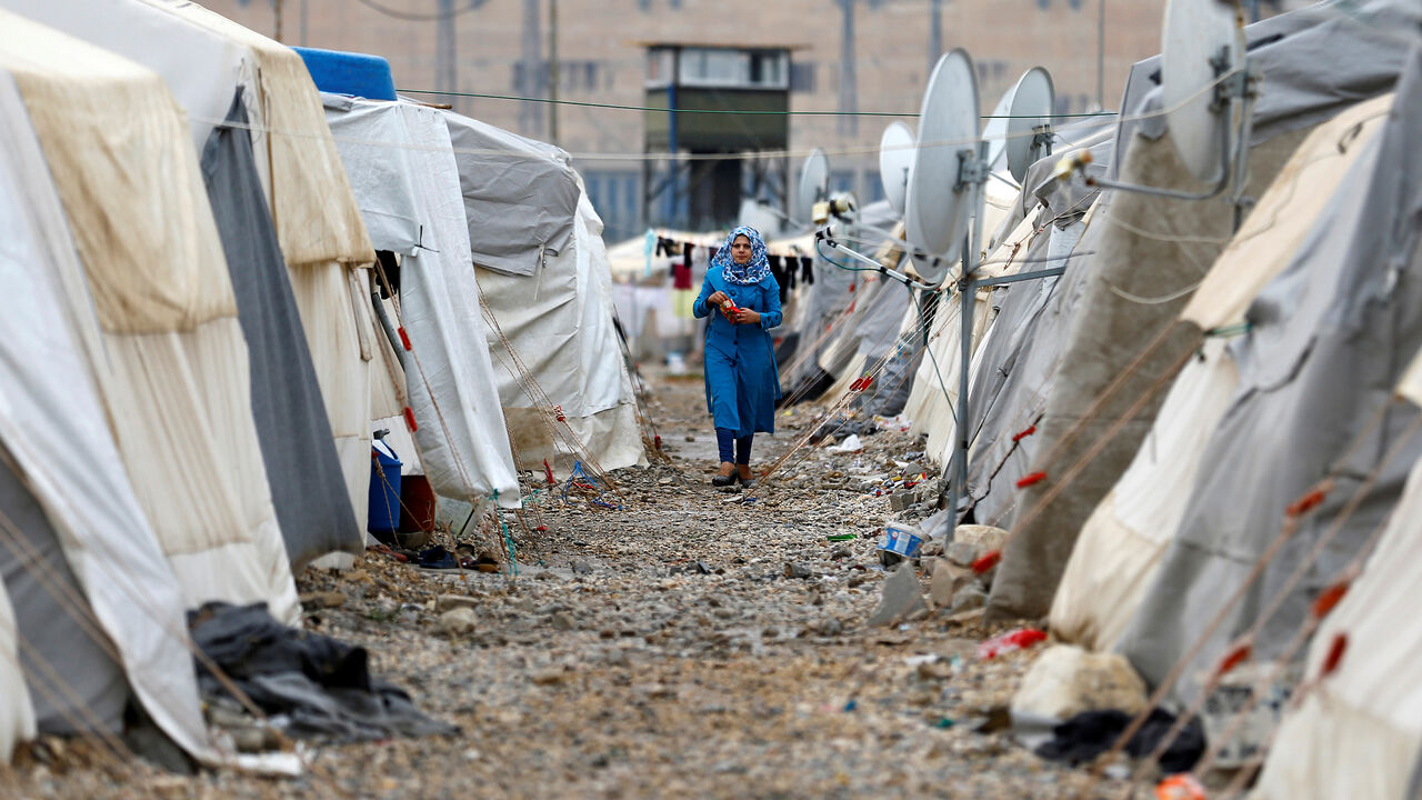 A Syrian refugee woman walks between tents in Nizip refugee camp, near the Turkish-Syrian border in Gaziantep province, Turkey, November 30, 2016. REUTERS/Umit Bektas - RC1B34636AE0