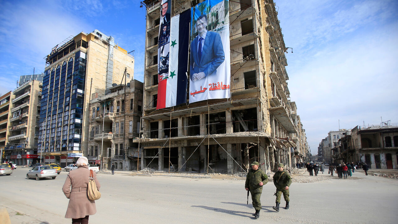 MIDEAST-CRISIS/ALEPPO-INFRASTRUCTURE Russian soldiers and civilians walk along a street in Aleppo, Syria January 30, 2017. Picture taken January 30, 2017. REUTERS/Ali Hashisho - RC150FD10090