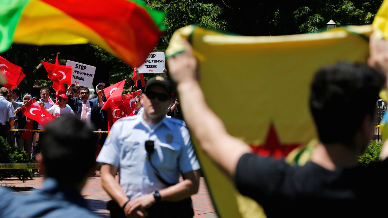 USA-TURKEY/ A group of pro-Erdogan demonstrators shout slogans at a group of anti-Erdogan Kurds (foreground, back to camera) in Lafayette Park as Turkey's President Tayyip Erdogan met with U.S. President Donald Trump nearby at the White House in Washington, U.S. May 16, 2017. REUTERS/Jonathan Ernst - RC11DF991CB0
