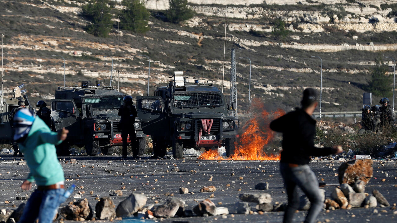 USA-TRUMP/ISRAEL Palestinian protesters hurl stones towards Israeli troops during clashes as Palestinians call for a "day of rage" in response to U.S. President Donald Trump's recognition of Jerusalem as Israel's capital, near the Jewish settlement of Beit El, near the West Bank city of Ramallah December 8, 2017. REUTERS/Mohamad Torokman - RC1AB20A9440
