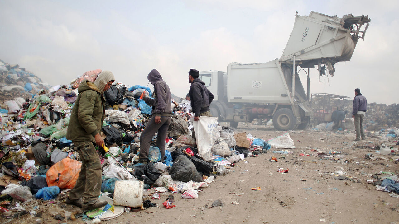 Palestinians search for recyclable waste and other items amid a pile of rubbish at a garbage dump in Rafah, in the southern Gaza Strip on April 16, 2015. AFP PHOTO / SAID KHATIB        (Photo credit should read SAID KHATIB/AFP/Getty Images)