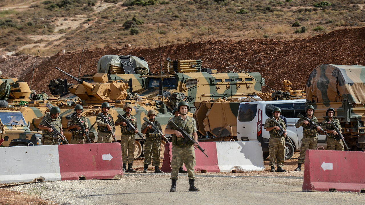 AFP_T95IE Turkish soldiers stand near armoured vehicles during a demonstration in support of the Turkish army's Idlib operation near the Turkey-Syria border near Reyhanli, Hatay, on October 10, 2017.
The Turkish army has launched a reconnaissance mission in Syria's largely jihadist-controlled northwestern Idlib province in a bid to create a de-escalation zone, the military said on October 9. / AFP PHOTO / ILYAS AKENGIN (Photo credit should read ILYAS AKENGIN/AFP/Getty Images)