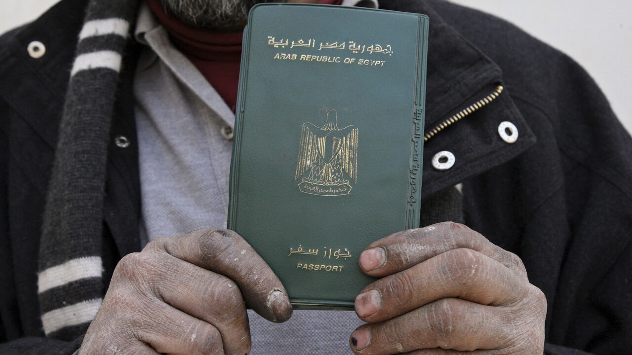 EGYPT-JORDAN/ An Egyptian man shows his passport after voting in a referendum on his country's new constitution at the Egyptian embassy in Amman January 9, 2014. Egyptians living outside the country on Wednesday began voting in a referendum on the new constitution. The referendum marks the first time Egyptians have voted since the removal of President Mohamed Mursi in July, and is seen as much as a public vote of confidence on the roadmap and army chief Abdel Fattah al-Sisi as the constitution itself. REUTERS/Majed Jaber