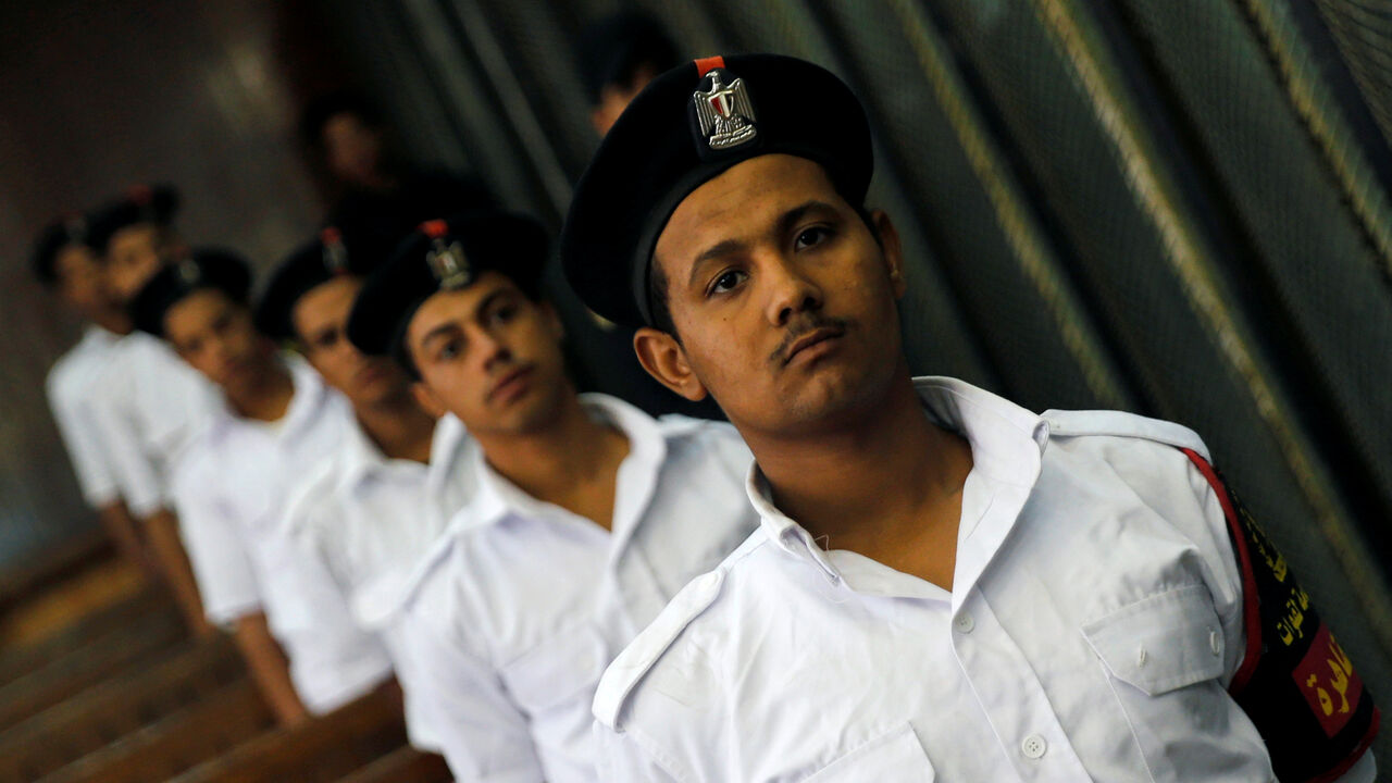 EGYPT-COURT/ Police officers stand guard as defendants accused of involvement in the 2015 assassination of Egypt's top prosecutor attend a hearing in a cage in a courtroom, on the outskirts of Cairo, Egypt, June 17, 2017. Picture taken June 17, 2017. REUTERS/Amr Abdallah Dalsh - RC153871D1A0