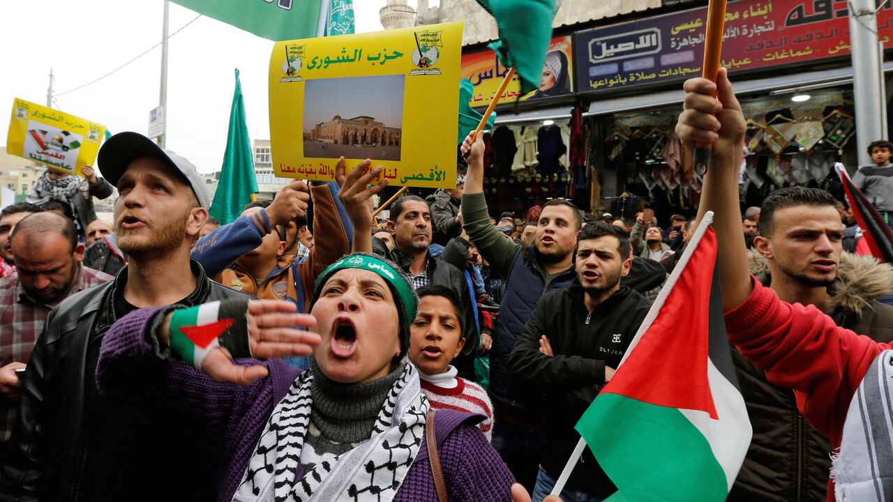 USA-TRUMP/ISRAEL People chant slogans during a protest against U.S. President Donald Trump's recognition of Jerusalem as Israel's capital, in Amman, Jordan December 29, 2017. The placard reads: "Al-Aqsa Mosque for us, and God with his strength with us". REUTERS/Muhammad Hamed - RC1388149230