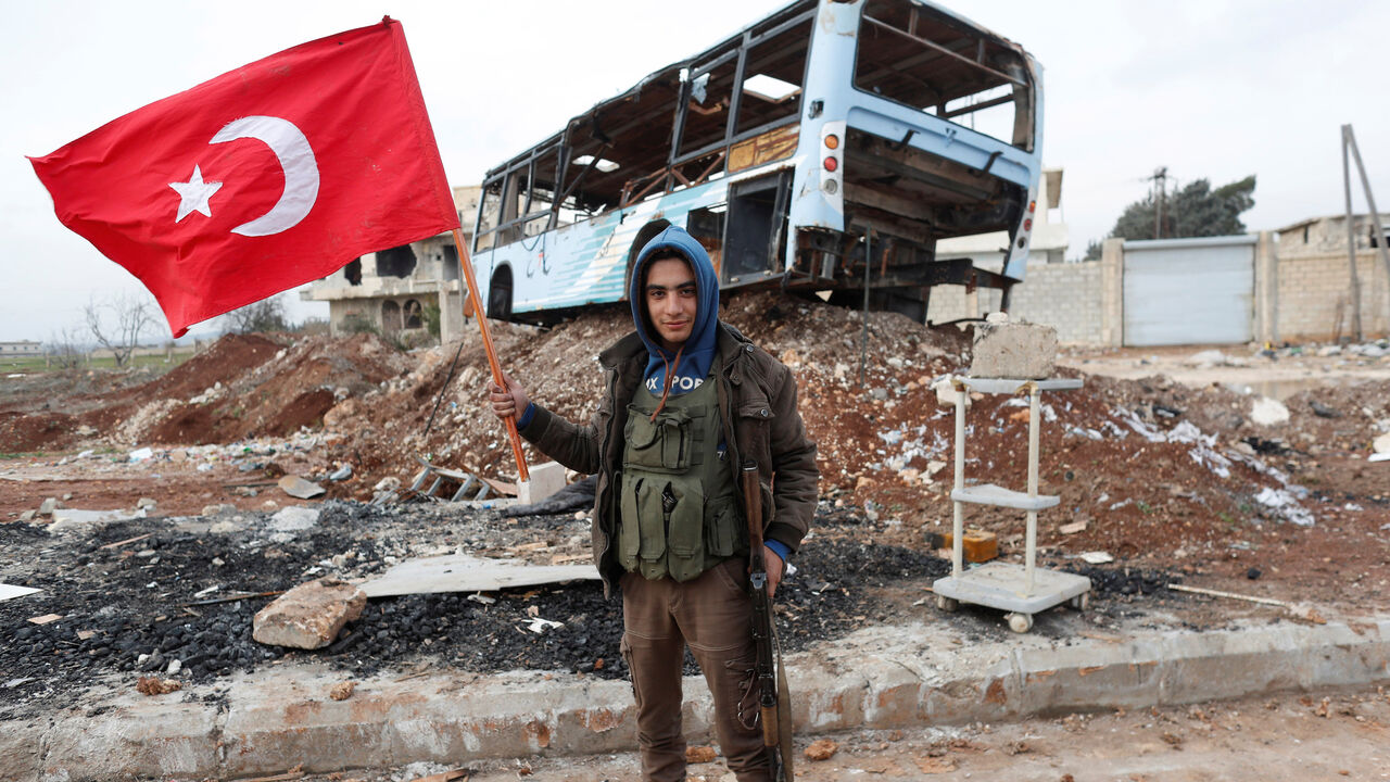 MIDEAST-CRISIS/SYRIA-TURKEY A Turkey-backed Free Syrian Army fighter holds a makeshift Turkish flag as he patrols on a road near Azaz, Syria January 21, 2018. REUTERS/Osman Orsal - RC12DBB08A80