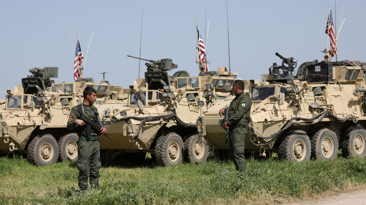 MIDEAST-CRISIS/SYRIA-KURDS Kurdish fighters from the People's Protection Units (YPG) stand near U.S military vehicles in the town of Darbasiya next to the Turkish border, Syria April 29, 2017. Picture taken April 29, 2017. REUTERS/Rodi Said - RC16C054E9B0