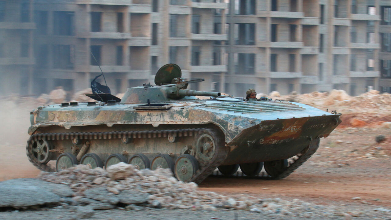 MIDEAST-CRISIS/SYRIA-ALEPPO A fighter of the Syrian Islamist rebel group Jabhat Fateh al-Sham, the former al Qaeda-affiliated Nusra Front, rides in an armoured vehicle in the 1070 Apartment Project area in southwestern Aleppo, Syria August 5, 2016. REUTERS/Ammar Abdullah - S1BETTTBXDAC