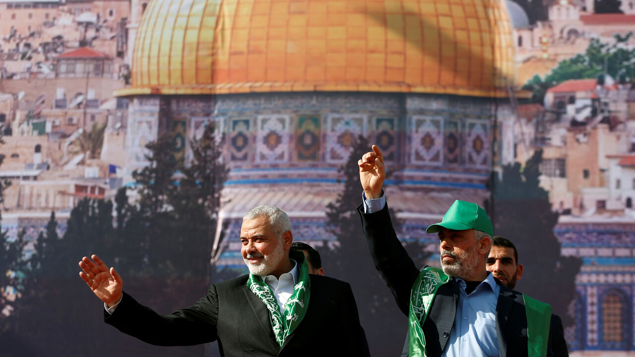 PALESTINIANS-HAMAS/ Hamas Chief Ismail Haniyeh and Gaza's Hamas Chief Yehya Al-Sinwar gesture to supporters during a rally marking the 30th anniversary of Hamas' founding, in Gaza City December 14, 2017. REUTERS/Mohammed Salem - RC1F66142030