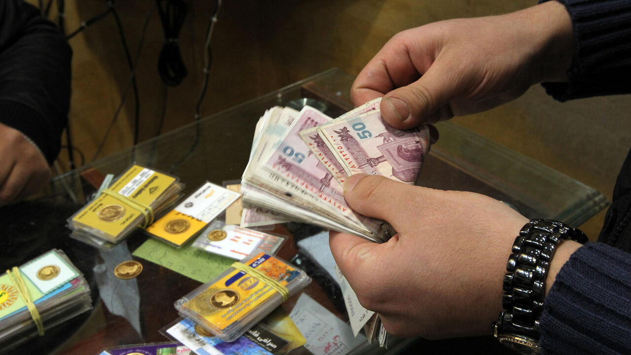 Nic6051864 An Iranian man counts banknotes after exchanging a gold coin for cash in Tehran on January 23, 2012. Gold coins were being exchanged for over 10,000,000 rials as the Iranian currency continued to lose value against the US dollar. Top European Union diplomats are meeting in Brussels to tighten existing sanctions on Iran by banning imports of Iranian crude as well as targeting finance, petrochemicals and gold to pressure the country. AFP PHOTO/ATTA KENARE (Photo credit should read ATTA KENARE/AFP/Getty Images