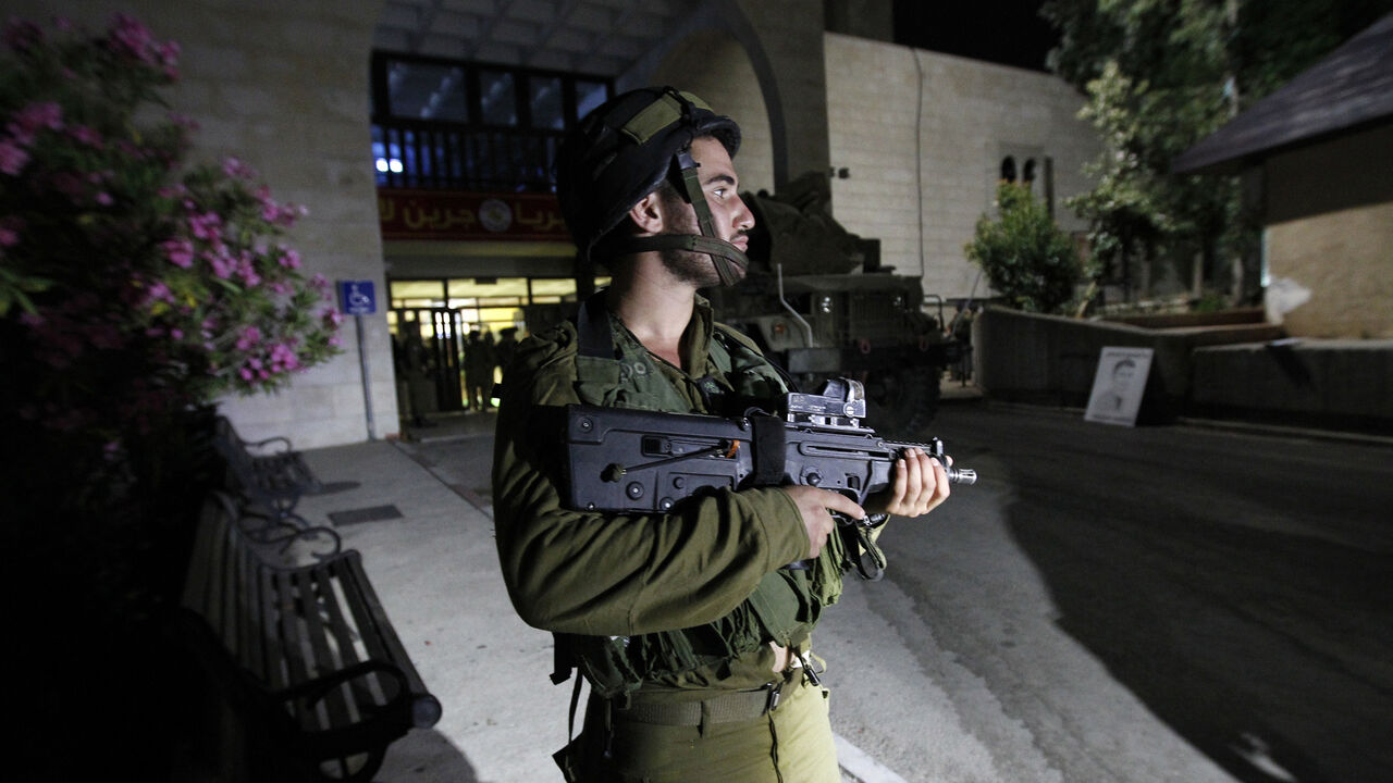 An Israeli soldier guards one of the entrances of Bir Zeit University near Ramallah during an operation in search for members of Islamist Hamas movement's on June 19, 2014. Israeli troops arrested some 30 Palestinians in the West Bank overnight as they ramped up a massive search for three teenagers believed kidnapped by Hamas, the army said.  AFP PHOTO/ ABBAS MOMANI        (Photo credit should read ABBAS MOMANI/AFP/Getty Images)