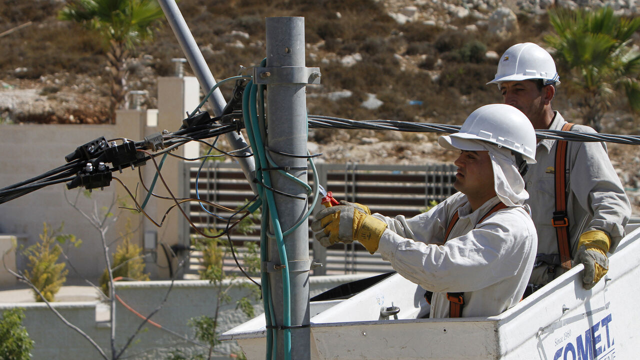 PALESTINIANS/ECONOMY Electricians install new power transmission lines at a construction site in the West Bank city of Ramallah September 3, 2012. The cash-strapped government of the occupied West Bank, the Palestinian Authority, is so behind with its bills that an Israeli electricity supplier has threatened to cut the power unless they pay outstanding debt of almost $80 million. Picture taken September 3, 2012. To match Feature PALESTINIANS/ECONOMY REUTERS/Mohamad Torokman (WEST BANK - Tags: POLITICS BUSINESS) - GM1E8951PIW01