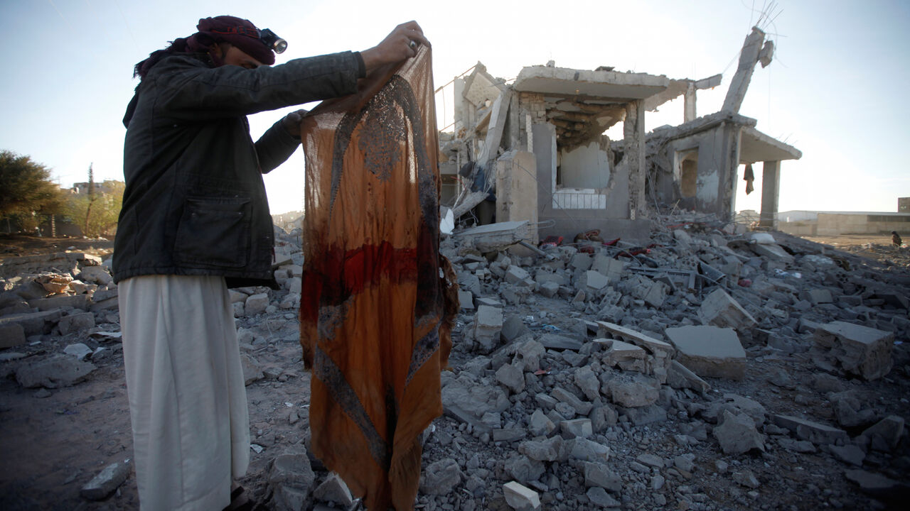 YEMEN-SECURITY/ A Houthi militant holds a blood-stained garment at the site of a Saudi-led air strike, north of Yemen's capital Sanaa, March 8, 2018. REUTERS/Mohamed al-Sayaghi - RC1D17254740