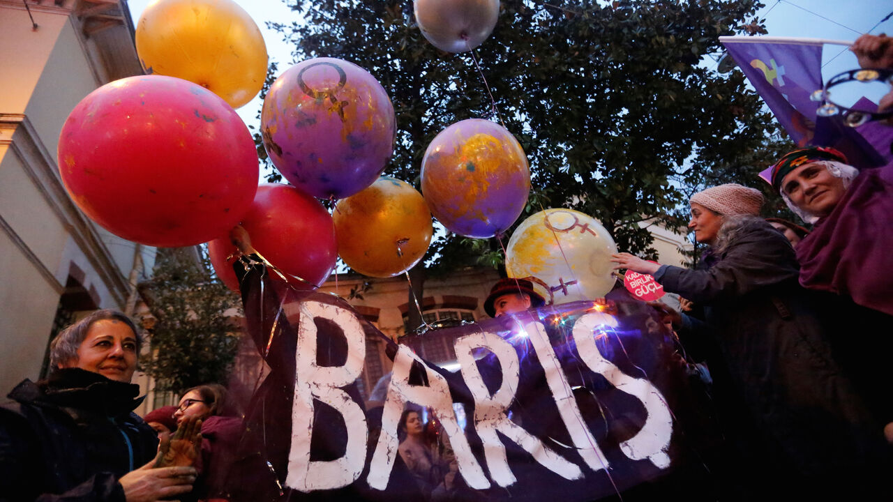 WOMENS-DAY/TURKEY Activists hold balloons with a banner reading "Peace" as they march at the main shopping and pedestrian street of Istiklal during a rally on the International Women's Day in Istanbul, Turkey March 8, 2018. REUTERS/Murad Sezer - RC1D2B73D500