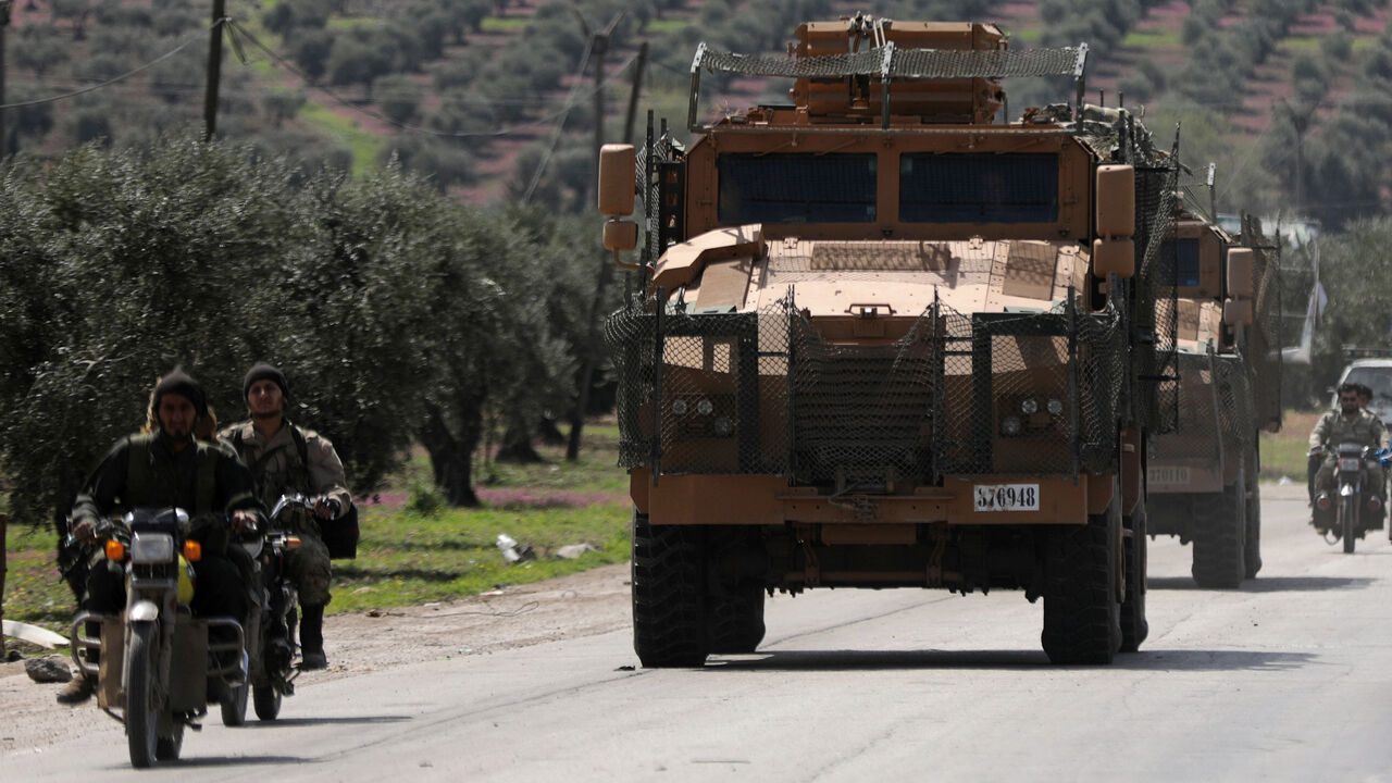 MIDEAST-CRISIS/SYRIA-AFRIN Turkish-backed Free Syrian army members ride on a motorbike near a Turkish military vehicle in Afrin, Syria March 19, 2018. REUTERS/Khalil Ashawi - RC1F92C97600