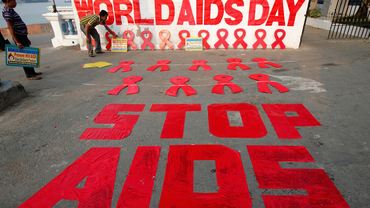 INDIA-HEALTH/ A man places a placard as he prepares a message during an HIV/AIDS awareness campaign on the eve of World AIDS Day in Kolkata, India, November 30, 2017. REUTERS/Rupak De Chowdhuri - RC1104607C00