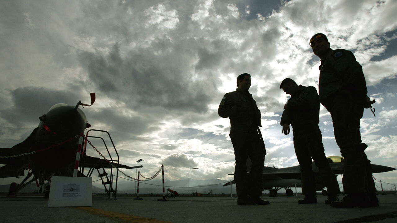 GREEK AIRFORCE Greek Air force pilots stand on the tarmac by F-16 Falcon fighting aircrafts in Nea Anchialos air force base some 300 km north of Athens November 8, 2004. Greek air force bases where open to the public on Monday as part of celebrations for the day of Archangel Michael, protector of the Greek air force. REUTER/Yannis Behrakis YB/THI - RP5DRHXPMGAC