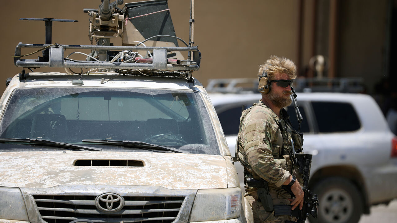 MIDEAST-CRISIS/SYRIA-TABQA U.S army soldier holds a gun as he stands guard next to an armoured vehicle as Brett McGurk, U.S. envoy to the coalition against Islamic State, visits the town of Tabqa, Syria June 29, 2017. REUTERS/Rodi Said - RC1AEEE29680