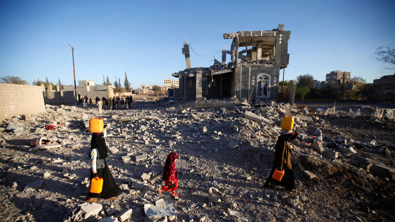 YEMEN-SECURITY/ People carry water tanks as they walk at the site of damage after a Saudi-led air strike, north of Yemen’s capital Sanaa, March 8, 2018. REUTERS/Mohamed al-Sayaghi - RC1A64C77B50