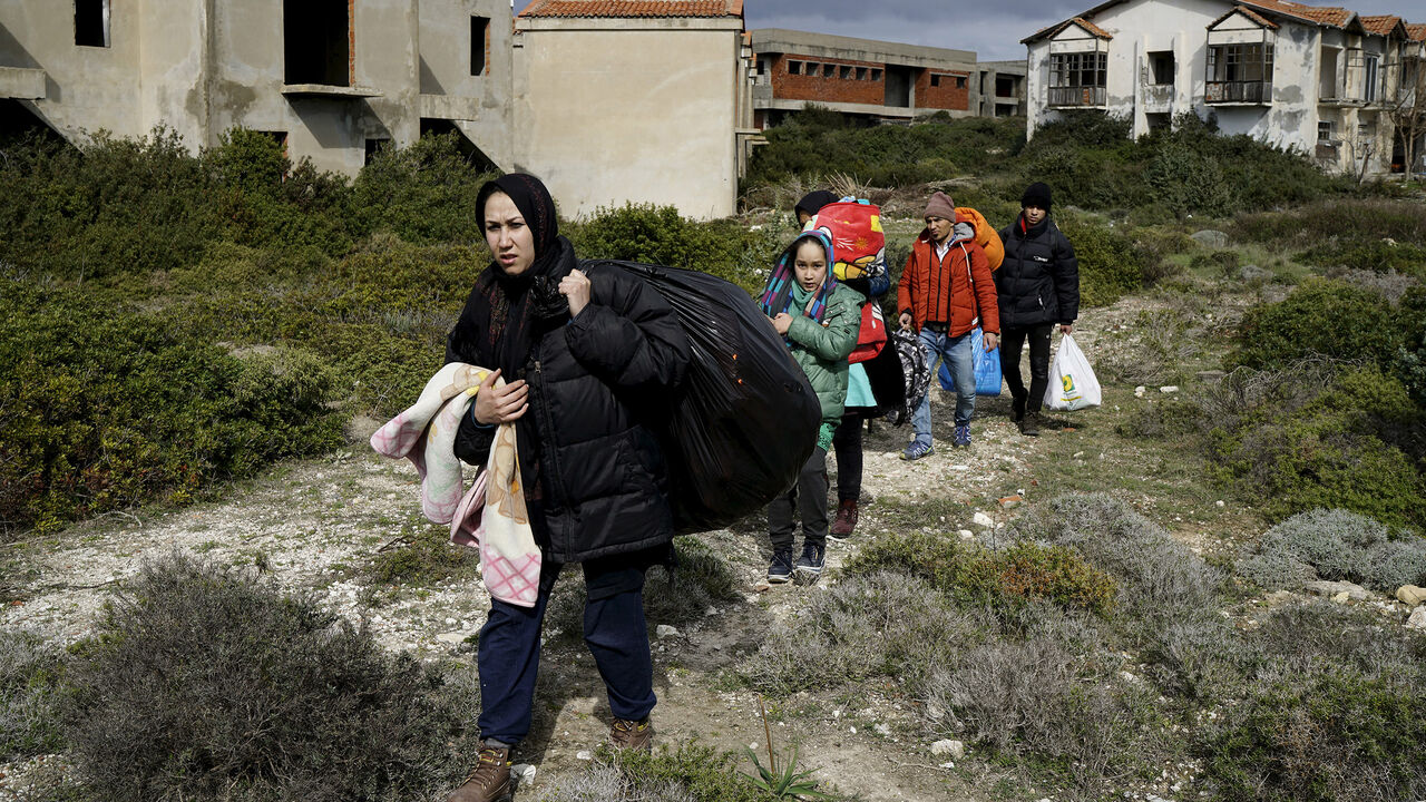 EUROPE-MIGRANTS/TURKEY Afghan refugees walk through a beach where they will wait to board a dinghy sailing off for the Greek island of Chios, while they try to travel from the western Turkish coastal town of Cesme, in Izmir province, Turkey, March 6, 2016. REUTERS/Umit Bektas TPX IMAGES OF THE DAY - GF10000335606