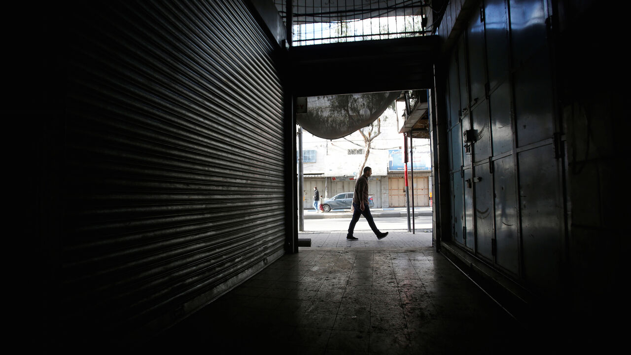 ISRAEL-PALESTINIANS-PROTESTS A man passes closed shops as Palestinians call for a general strike, in Hebron, in the occupied West Bank March 31, 2018. REUTERS/Mussa Qawasma - RC1243688B00