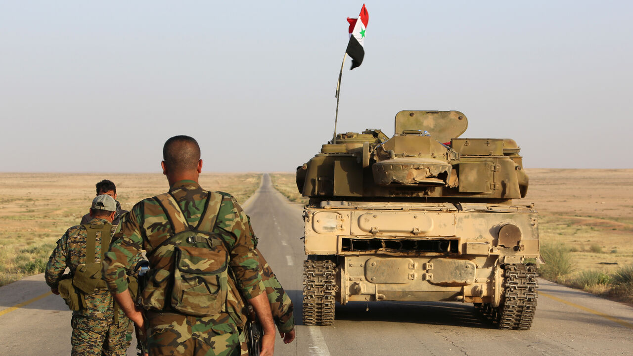 Syrian government forces secure a road for a military convoy in the desert area of Saba' Biyar, in southeastern Syria near the border with Iraq, on May 10, 2017, as fierce clashes are reported in the region. / AFP PHOTO / STRINGER        (Photo credit should read STRINGER/AFP/Getty Images)