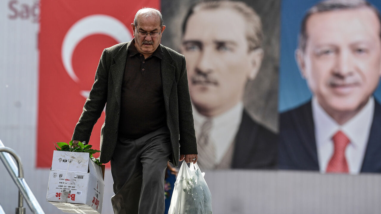 AFP_14R9HD A man walks in front of the portraits of Turkish President Recep Tayyip Erdogan (R) and founder of modern Turkey Mustafa Kemal Ataturk (L), on May 11, 2018 at Emininonu district in Istanbul. - President Recep Tayyip Erdogan called snap elections in Turkey for June 24, bringing the polls forward by over a year and a half after a call from his main nationalist ally on April 18, 2018. (Photo by OZAN KOSE / AFP) (Photo credit should read OZAN KOSE/AFP/Getty Images)