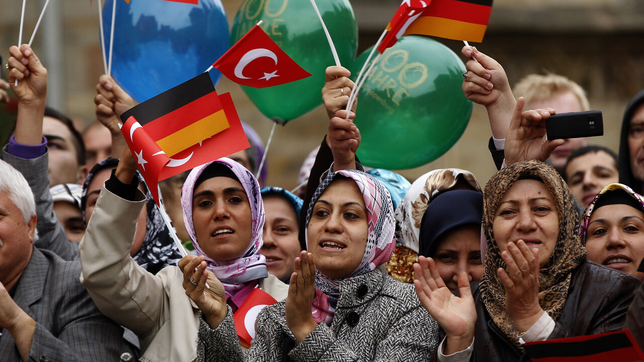 GERMANY/ Turkish women wave German and Turkish flags during a visit of Turkey's President Abdullah Gul in Osnabrueck September 20, 2011. REUTERS/Ina Fassbender (GERMANY - Tags: POLITICS) - BM2E79K144D01