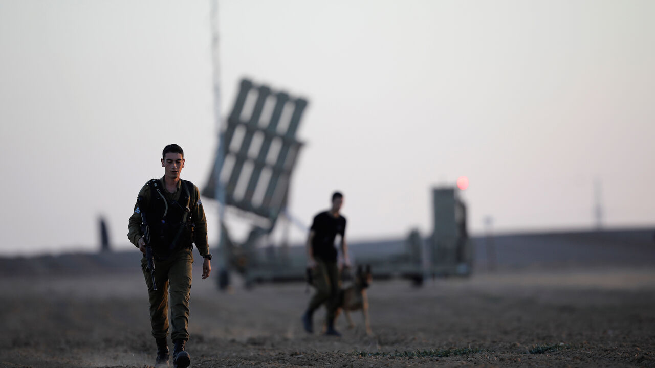 PALESTINIANS-ISRAEL/TUNNEL Israeli soldiers walk past an Iron Dome rocket interceptor battery deployed near central Gaza Strip, southern Israel October 31, 2017. REUTERS/Amir Cohen - RC173427FF50