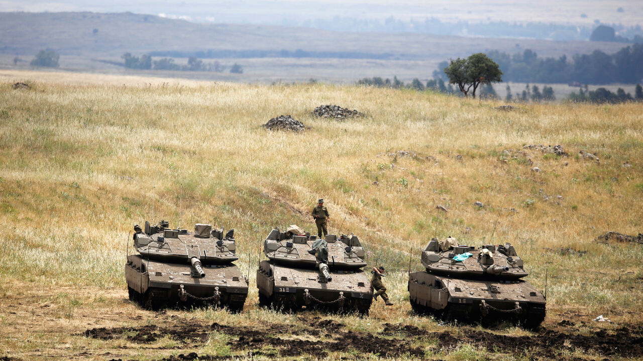 MIDEAST-CRISIS-SYRIA-ISRAEL An Israeli soldier stands on a tank as another jumps off it near the Israeli side of the border with Syria in the Israeli-occupied Golan Heights, Israel May 9, 2018. REUTERS/Amir Cohen - RC1520FF8190