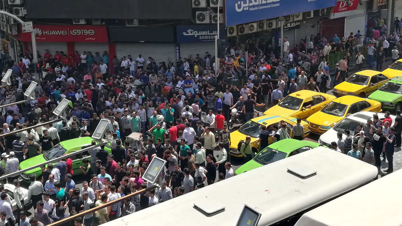 AFP_16L14B Iranian protesters gather at Mobile market in Tehran on June 25, 2018. - Protesters in Tehran shouted slogans and threw rocks in the streets on June 25, before being dispersed by anti-riot policemen. (Photo by ATTA KENARE / AFP) (Photo credit should read ATTA KENARE/AFP/Getty Images)