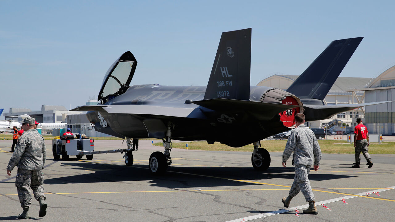 AIRSHOW-PARIS/ U.S. airmen walk next to a Lockheed Martin F-35 Lightning II aircraft, as it is moved, on the eve of the 52nd Paris Air Show at Le Bourget Airport near Paris, France June 18, 2017. REUTERS/Pascal Rossignol - RC15E3E8E180