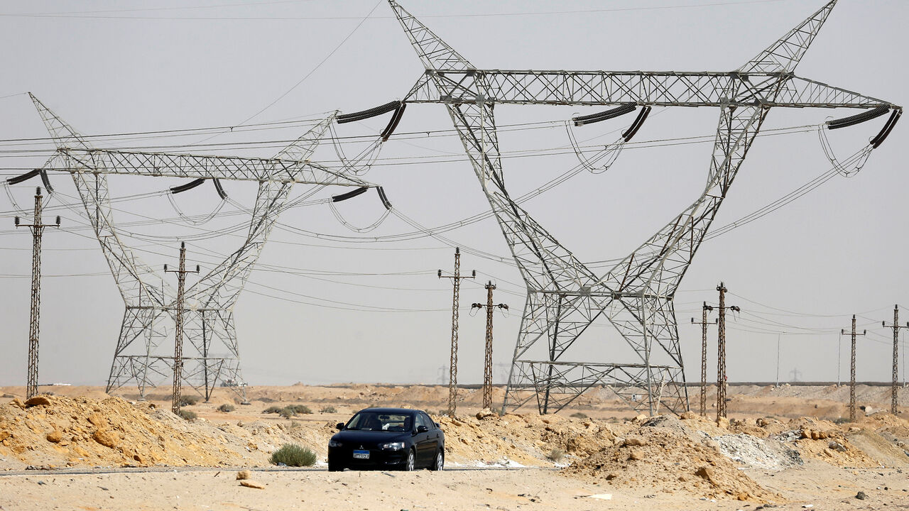 GLOBAL-ENERGY/ A car passes power lines connecting pylons of high-tension electricity at the highway in Cairo, Egypt August 14, 2017. REUTERS/Amr Abdallah Dalsh - RC122337A6E0