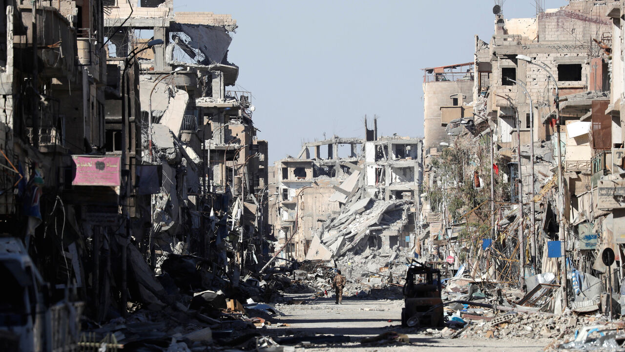 MIDEAST-CRISIS/SYRIA-RAQQA A fighter of Syrian Democratic Forces stands amidst the ruins of buildings near the Clock Square in Raqqa, Syria October 18, 2017. Picture taken October 18, 2017. REUTERS/Erik De Castro - RC1E4E003870