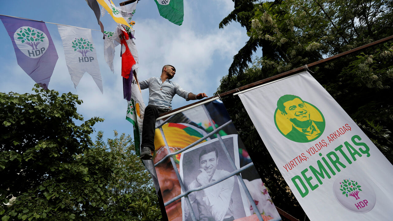 TURKEY-ELECTION/HDP A supporter of the pro-Kurdish Peoples' Democratic Party (HDP) hangs posters of Selahattin Demirtas, the party's jailed former co-leader and the candidate for the upcoming presidential election, during a gathering in Istanbul, Turkey May 4, 2018. REUTERS/Murad Sezer - RC18E770B250