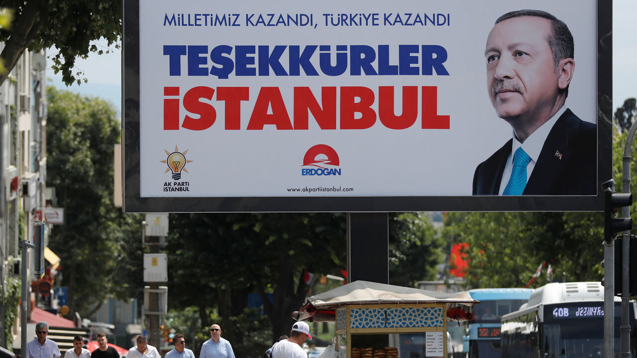 TURKEY-ELECTION/ People walk past a poster for Turkey's President Tayyip Erdogan in Istanbul, Turkey, June 25, 2018. The poster reads: "Our people won, Turkey won, Thank you istanbul". REUTERS/Osman Orsal - RC19D0C486D0