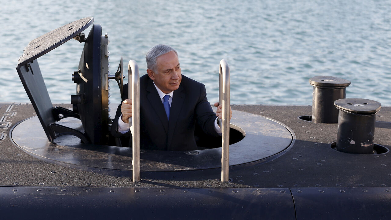 ISRAEL-ARMS/ Israeli Prime Minister Benjamin Netanyahu climbs out after a visit inside the Rahav, the fifth submarine in the Israeli Navy's fleet, after it arrived in Haifa port January 12, 2016. The Dolphin-class submarines, widely believed to be capable of firing nuclear missiles, were manufactured in Germany and sold to Israel at deep discounts as part of Berlin's commitment to shoring up the security of the country set in part as a haven for Jews who survived the Holocaust. REUTERS/Baz Ratner - GF20000092316