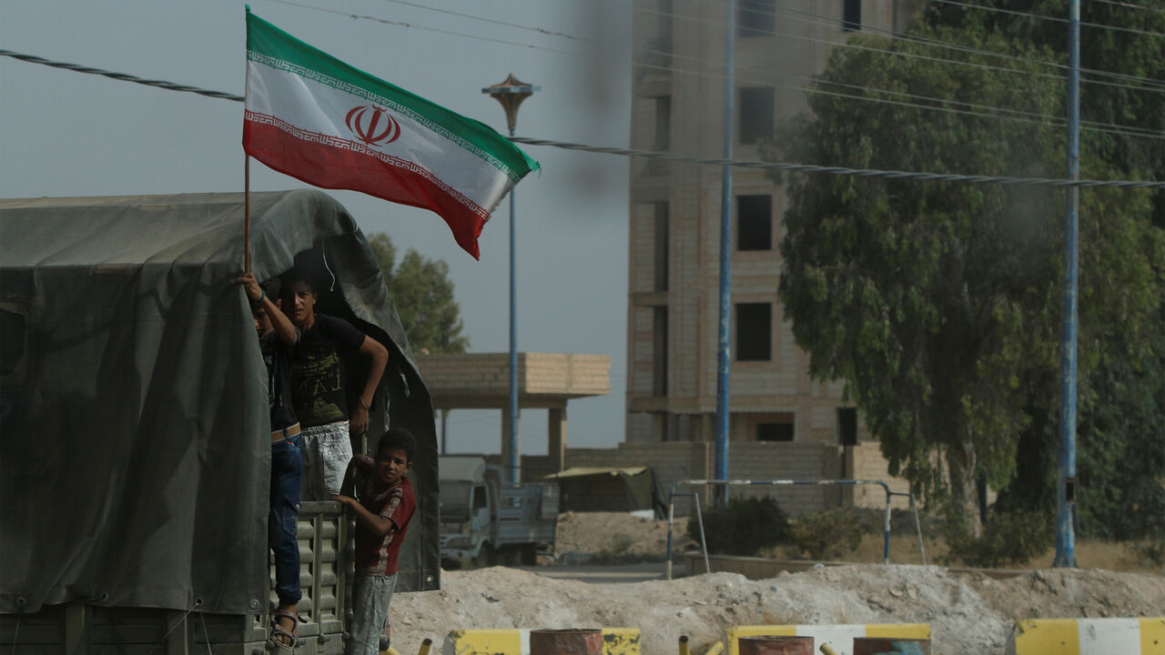 MIDEAST-CRISIS/SYRIA-DEIR AL-ZOR Iranian flag flutters on a truck carrying humanitarian aid in Deir al-Zor, Syria September 20, 2017. Picture taken September 20, 2017. REUTERS/Omar Sanadiki - RC1AFCE7F550