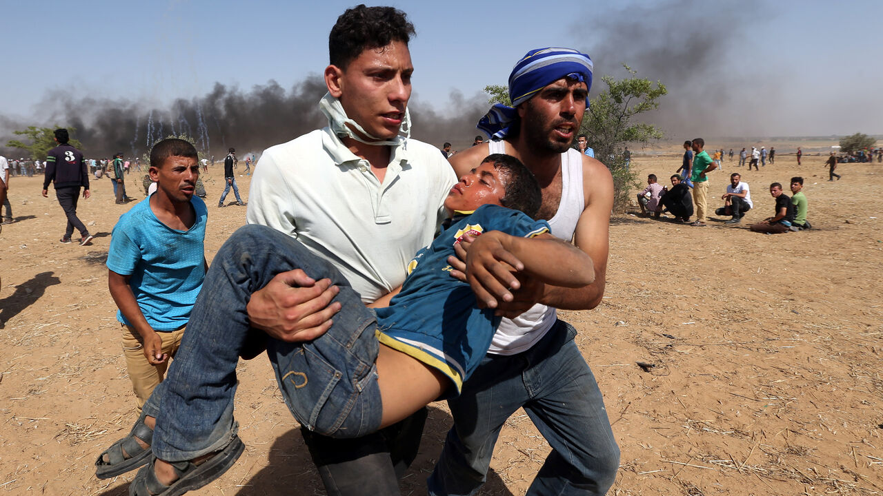 ISRAEL-PALESTINIANS/PROTESTS A wounded Palestinian boy is evacuated during a protest marking al-Quds Day, (Jerusalem Day), at the Israel-Gaza border in the southern Gaza Strip June 8, 2018. REUTERS/Ibraheem Abu Mustafa - RC1DC5C1B3A0