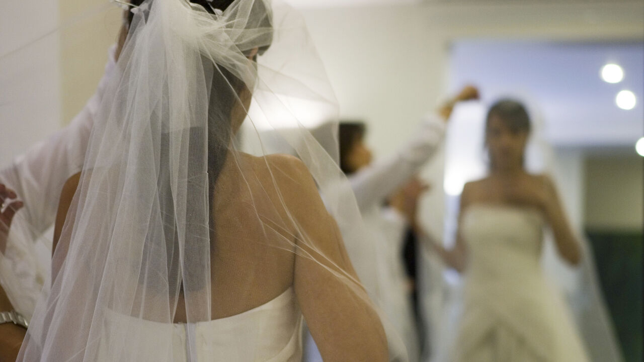 IRAN FASHION/ An Iranian dress designer checks the fit of a veil on a bride at a high fashion studio in north Tehran October 2, 2007. Wearing the all-enveloping chador (veil) or a headscarf and loose-fitting full-length coat is obligatory under Sharia law, imposed after the 1979 Islamic revolution. Offenders face fines, whipping or jail. But that has not stopped image-conscious Iranian women and a growing number are going under the knife for new noses, tummy tucks, liposuction, lifting eyelids or breast augmentation. Pic