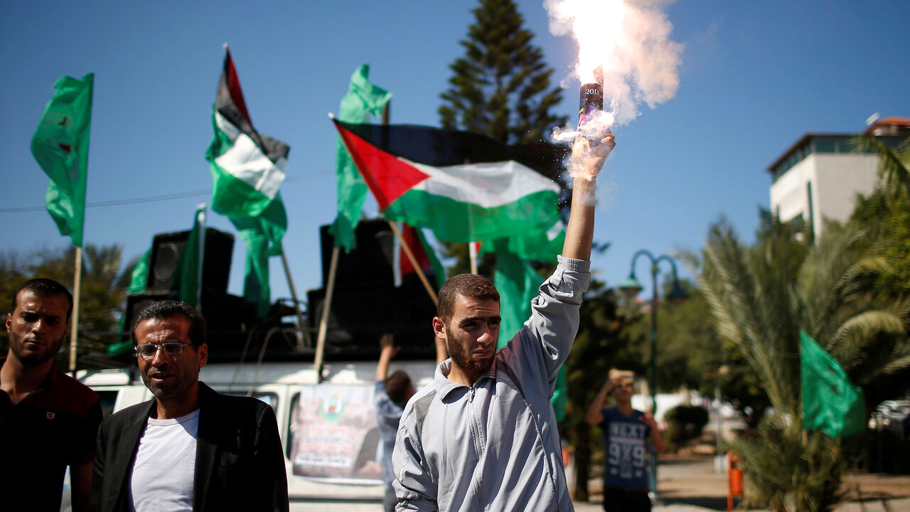 PALESTINIANS-RECONCILIATION/MOOD A man releases fireworks during celebrations after rival Palestinian factions Hamas and Fatah signed a reconciliation deal, in Gaza City October 12, 2017. Picture taken October 12, 2017. REUTERS/Suhaib Salem - RC1D1B95D160