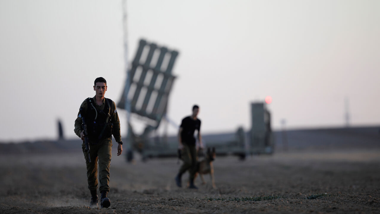PALESTINIANS-ISRAEL/TUNNEL Israeli soldiers walk past an Iron Dome rocket interceptor battery deployed near central Gaza Strip, southern Israel October 31, 2017. REUTERS/Amir Cohen - RC173427FF50