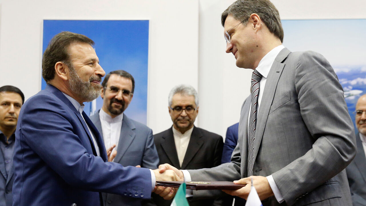 RUSSIA-IRAN/ Russian Energy Minister Alexander Novak and Iranian Communications Minister Mahmoud Vaezi exchange documents during a signing ceremony after their meeting in Moscow, Russia, July 29, 2016. REUTERS/Maxim Zmeyev - D1BETSIUABAB