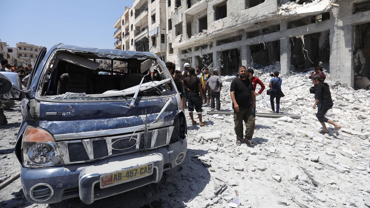 AFP_1833MP Syrians gather at a site of car bomb in the northwestern Syrian city of Idlib on August 2, 2018. - Idlib is the last of four "de-escalation" zones agreed by world powers in 2017 where the rebels still have a major presence. Strategically important Idlib province shares a border with rebel-backer Turkey and is adjacent to Latakia, a regime stronghold on the Mediterranean. (Photo by OMAR HAJ KADOUR / AFP) (Photo credit should read OMAR HAJ KADOUR/AFP/Getty Images)