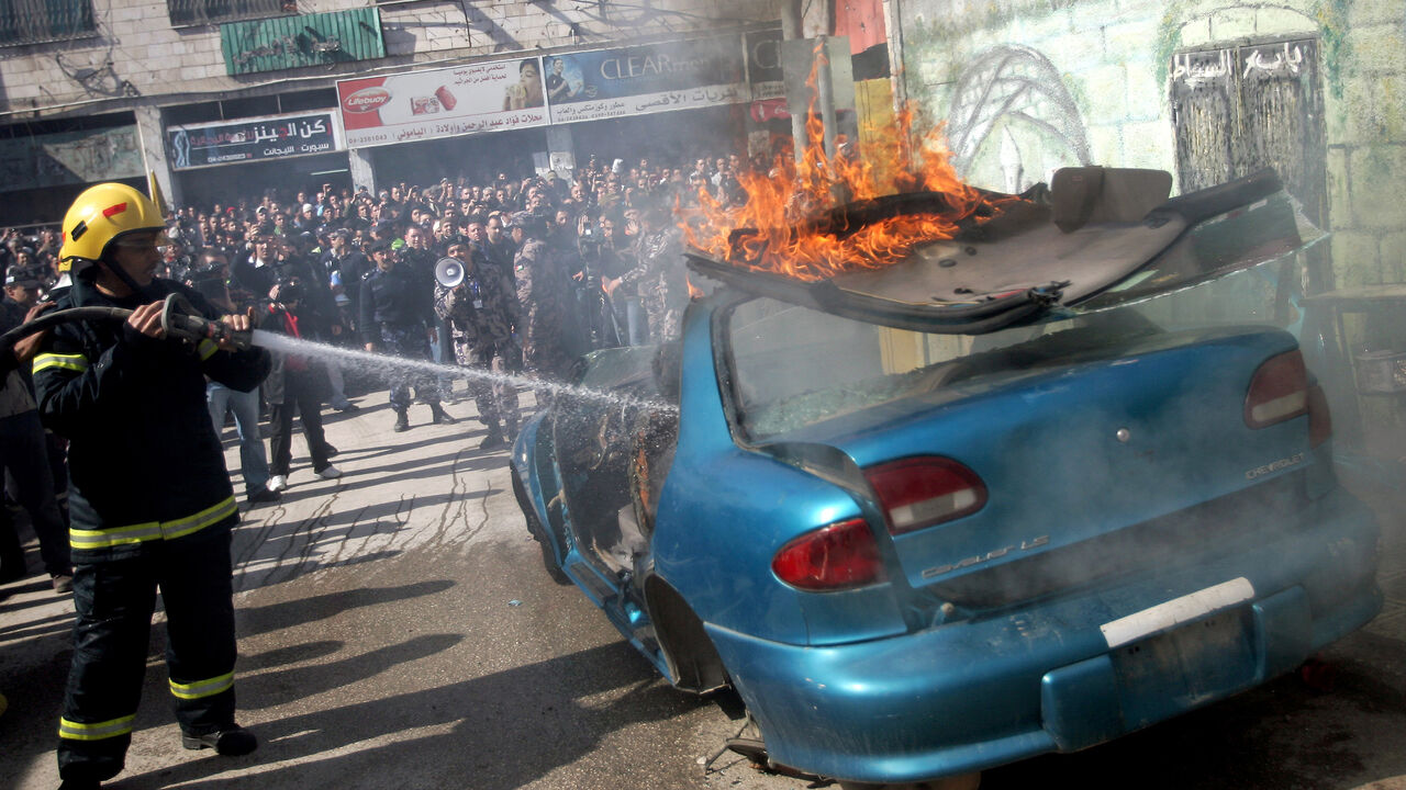 Nic6062691 A Palestinian firefighter douses a burning car during an earthquake drill organised by the civil defence forces in the West Bank city of Jenin on February 16, 2012. AFP PHOTO/SAIF DAHLAH (Photo credit should read SAIF DAHLAH/AFP/Getty Images)