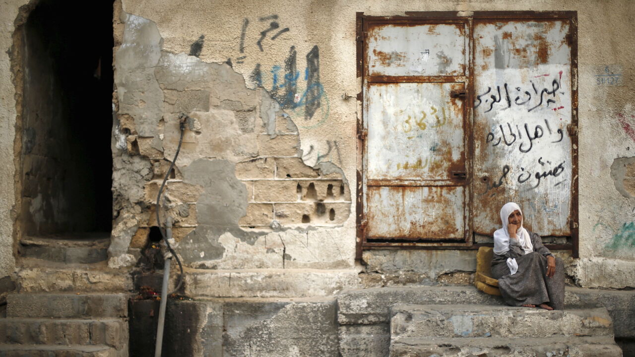 PALESTINIANS-ENERGY/ A Palestinian woman sits outside her house as she escapes the heat during a power cut at Shatti (beach) refugee camp in Gaza City September 15, 2015. Power has been provided to different areas in the impoverished coastal territory in six-hour shifts as Gaza's lone power plant shut its generators on Saturday due to a fuel shortage, energy officials said. Electricity is also supplied to the Gaza grid through power lines from Israel and Egypt. Gaza's plant provides electricity to two-thirds of its population.