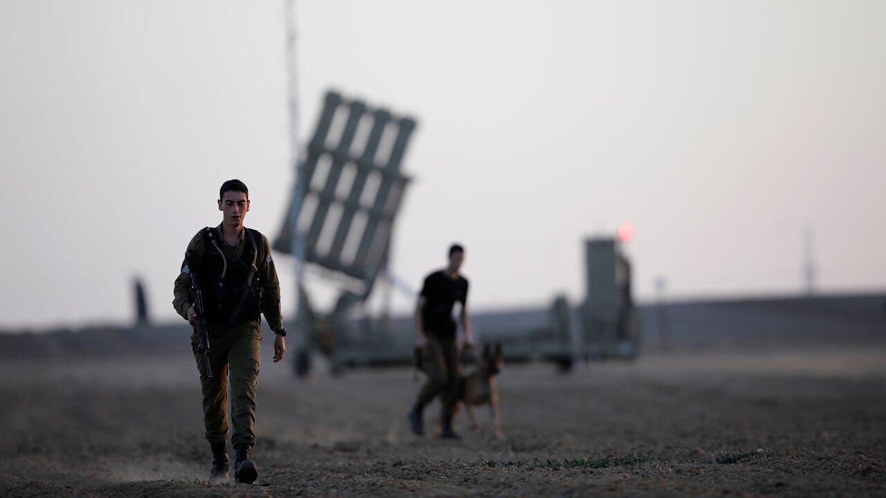 PALESTINIANS-ISRAEL/TUNNEL Israeli soldiers walk past an Iron Dome rocket interceptor battery deployed near central Gaza Strip, southern Israel October 31, 2017. REUTERS/Amir Cohen - RC173427FF50