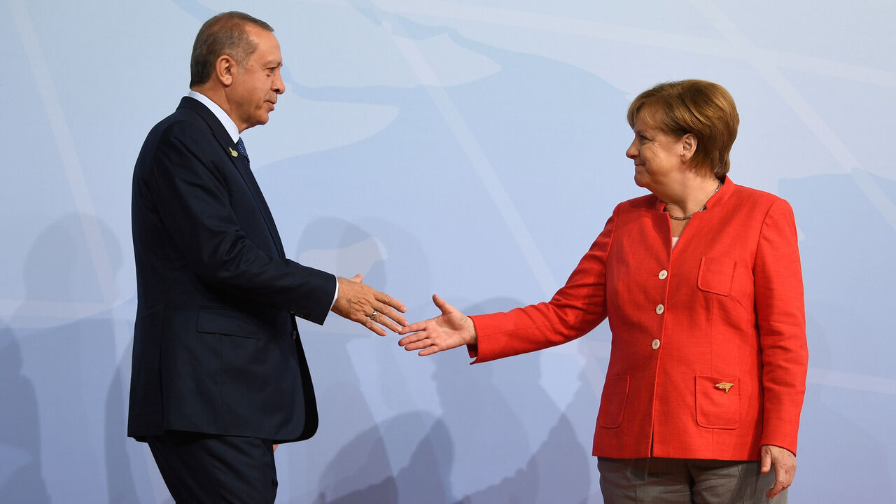 G20-GERMANY/ German Chancellor Angela Merkel greets Turkey's President Recep Tayyip Erdogan at the beginning of the G20 summit in Hamburg, Germany, July 7, 2017. REUTERS/Bernd Von Jutrczenka/POOL - RC16778A3FD0