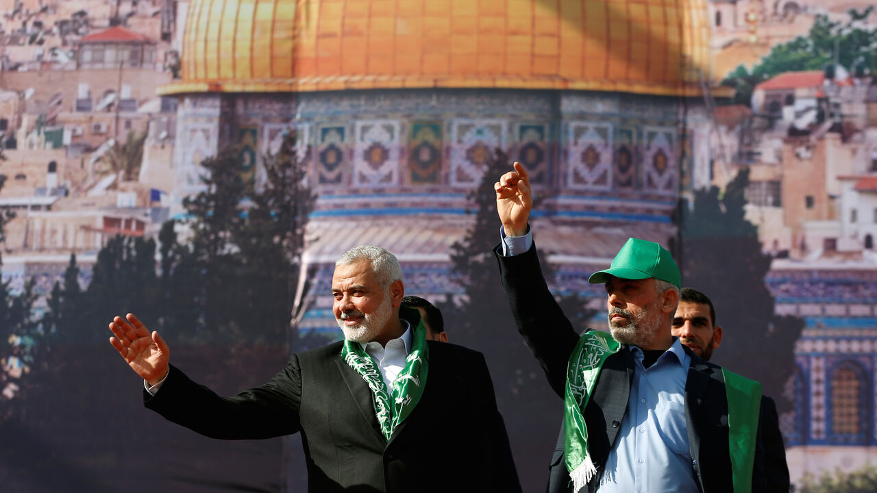 PALESTINIANS-HAMAS/ Hamas Chief Ismail Haniyeh and Gaza's Hamas Chief Yehya Al-Sinwar gesture to supporters during a rally marking the 30th anniversary of Hamas' founding, in Gaza City December 14, 2017. REUTERS/Mohammed Salem - RC1F66142030
