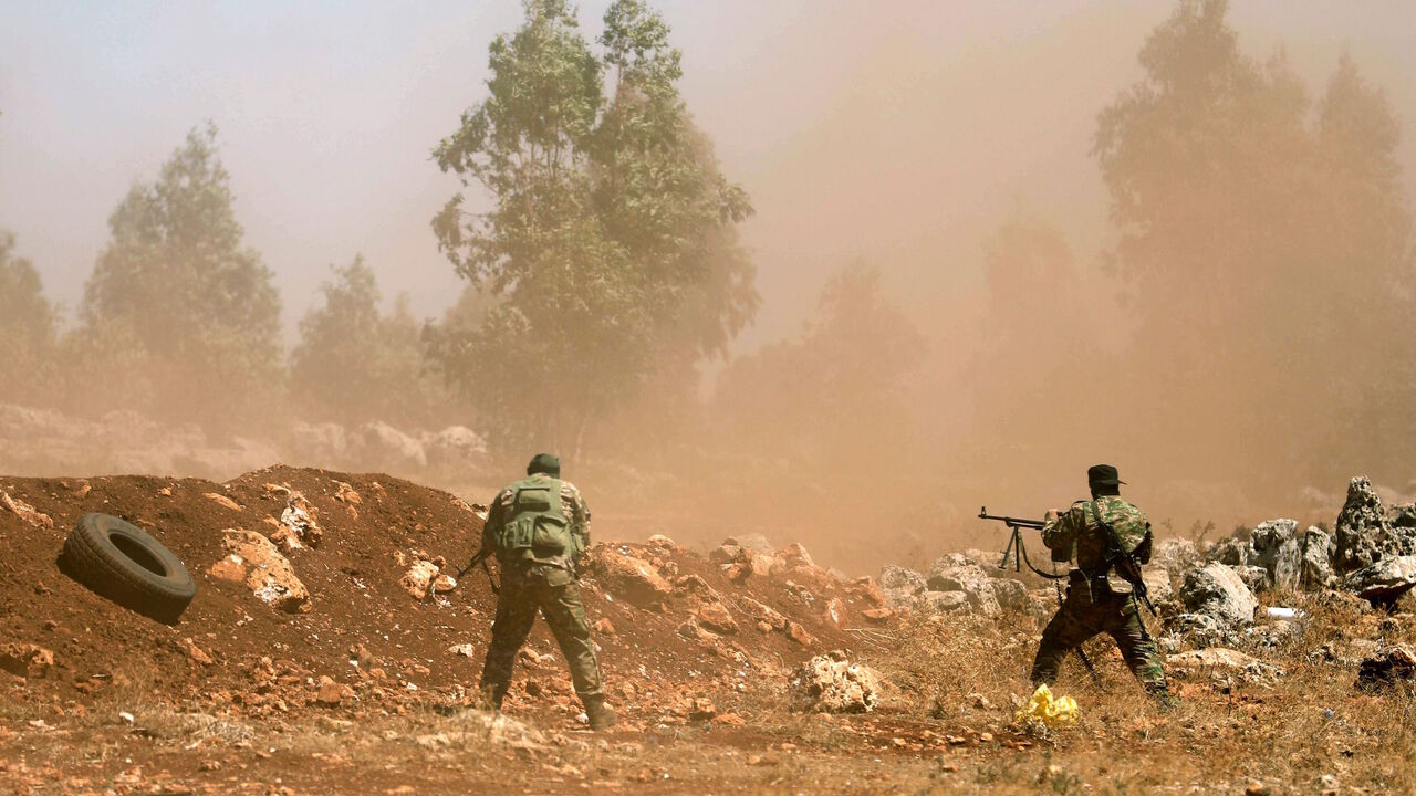 AFP_18D4JA Syrian fighters fire their rifles as they attend a mock battle in anticipation of an attack by the regime on Idlib province and the surrounding countryside, during a graduation of new Hayat Tahrir al-Sham (HTS) members at a camp in the countryside of the northern Idlib province on August 14, 2018. (Photo by OMAR HAJ KADOUR / AFP) (Photo credit should read OMAR HAJ KADOUR/AFP/Getty Images)